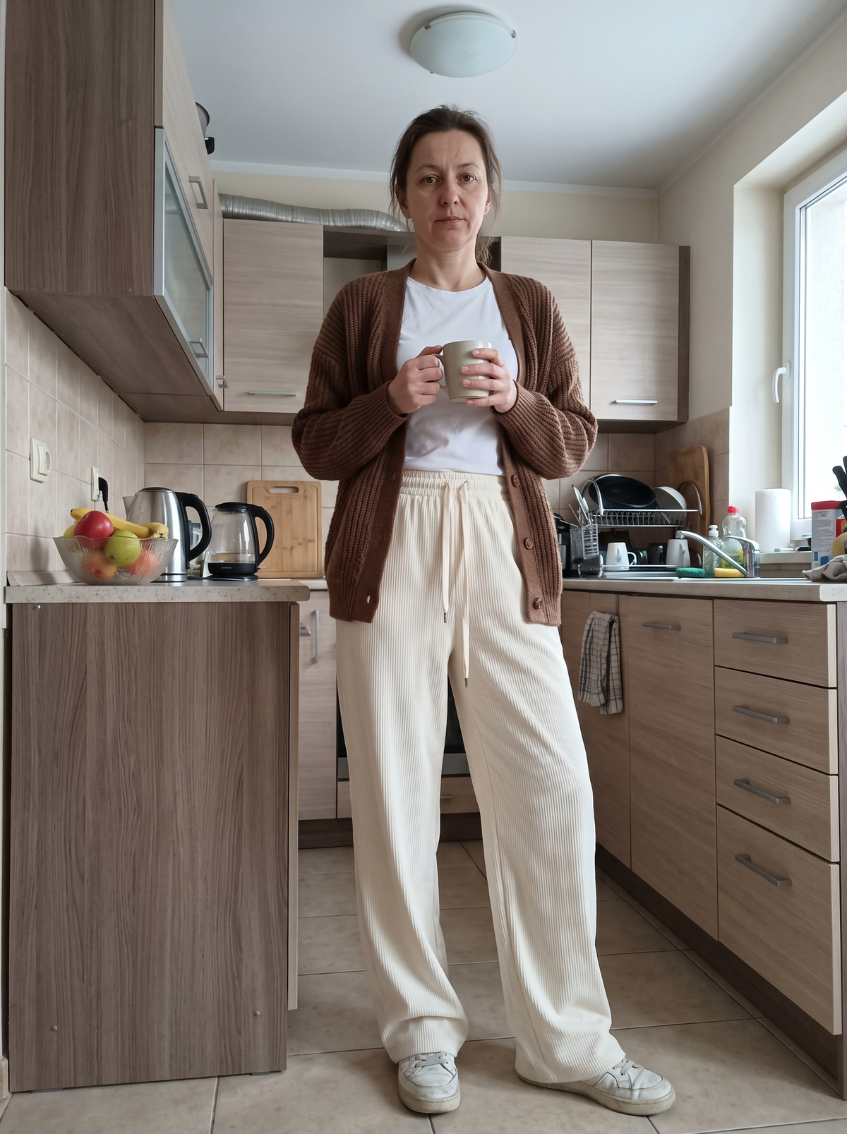 Kremowe sztruksowe spodnie Joanna z szerokimi nogawkami w kuchni